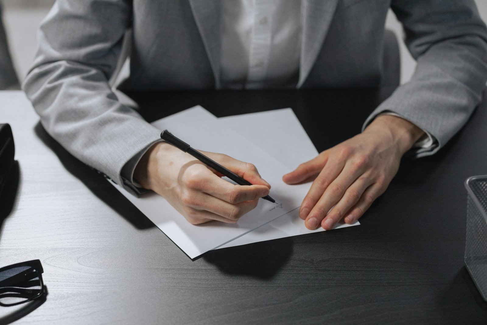 Professional hands signing a document in an office setting for business purposes.